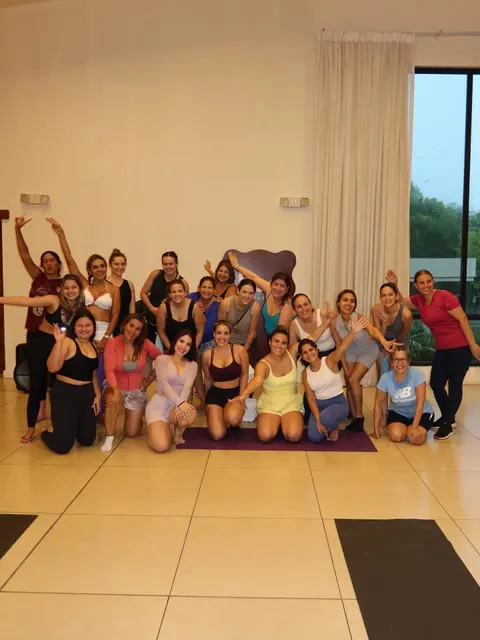 Paola Porcell con un grupo de alumnas posando felices y con los brazos arriba al final de una clase